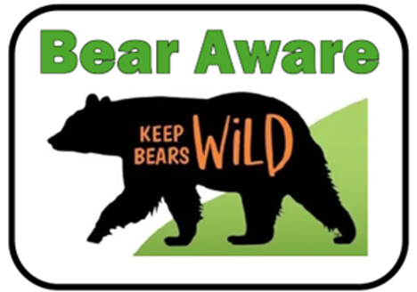 A sign with a bear silhouette and the words KEEP BEARS WILD inside. Above the bear, Bear Aware is written in green bold letters, all set against a green and white background.