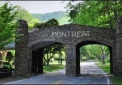 A stone archway labeled “Montreat” spans over a two-lane road, surrounded by lush green trees with mountains visible in the background.