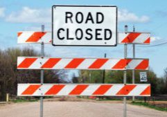 Dusty road closed sign on a country road